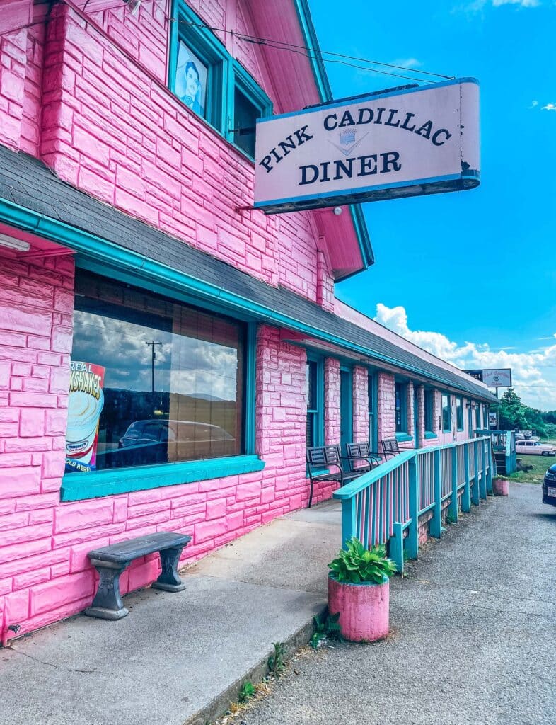 A bright pink building with a sign that reads "Pink Cadillac Diner"