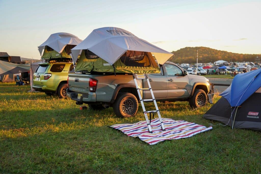 Vehicles set up to camp with rooftop tents overlook Overland Expo East