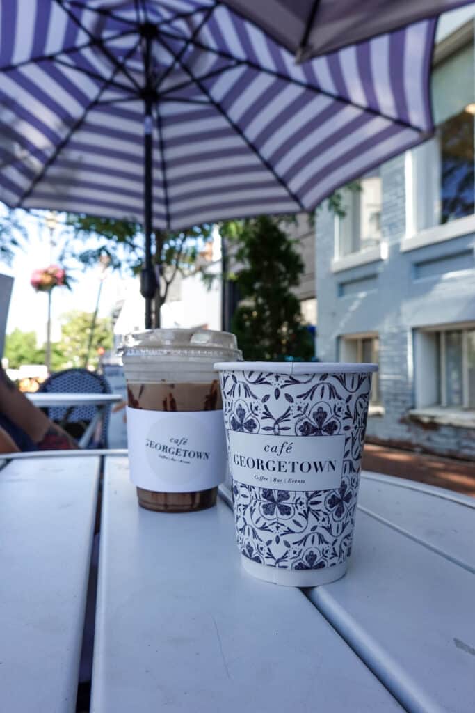 Coffee cups reading "Cafe Georgetown" on an outdoor patio table